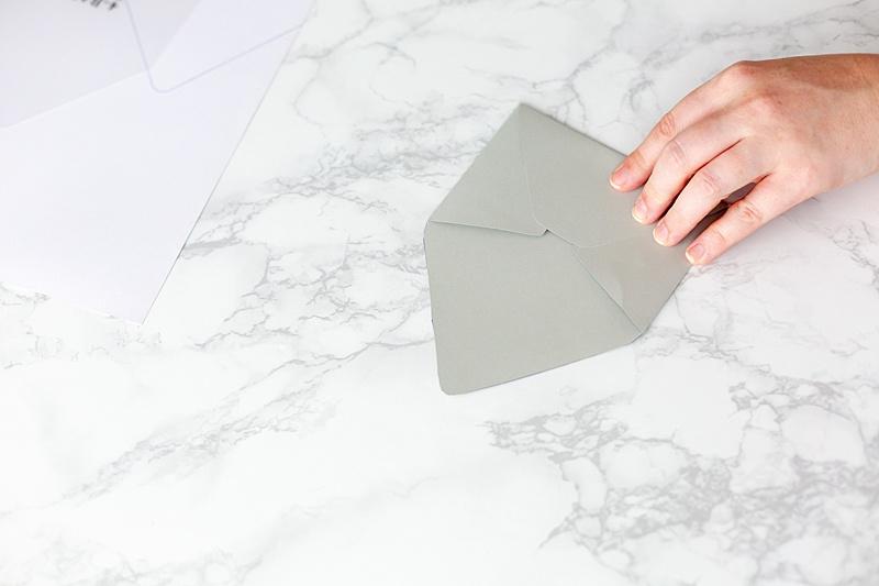  Fold up the bottom flap and crease it as well. Use your adhesive of choice to adhere the bottom flap to the side flaps. Be careful not to stick it to the inside of the envelope. 